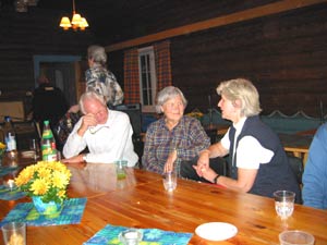Oddvar og Gerd i samtale med Berit. Bak gr en annen Berit ut etter mer vann i glasset.